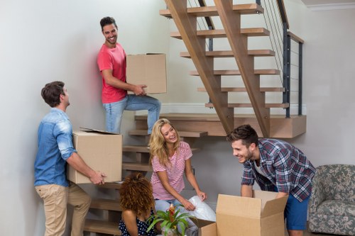 Trained movers working carefully with boxes and protective equipment